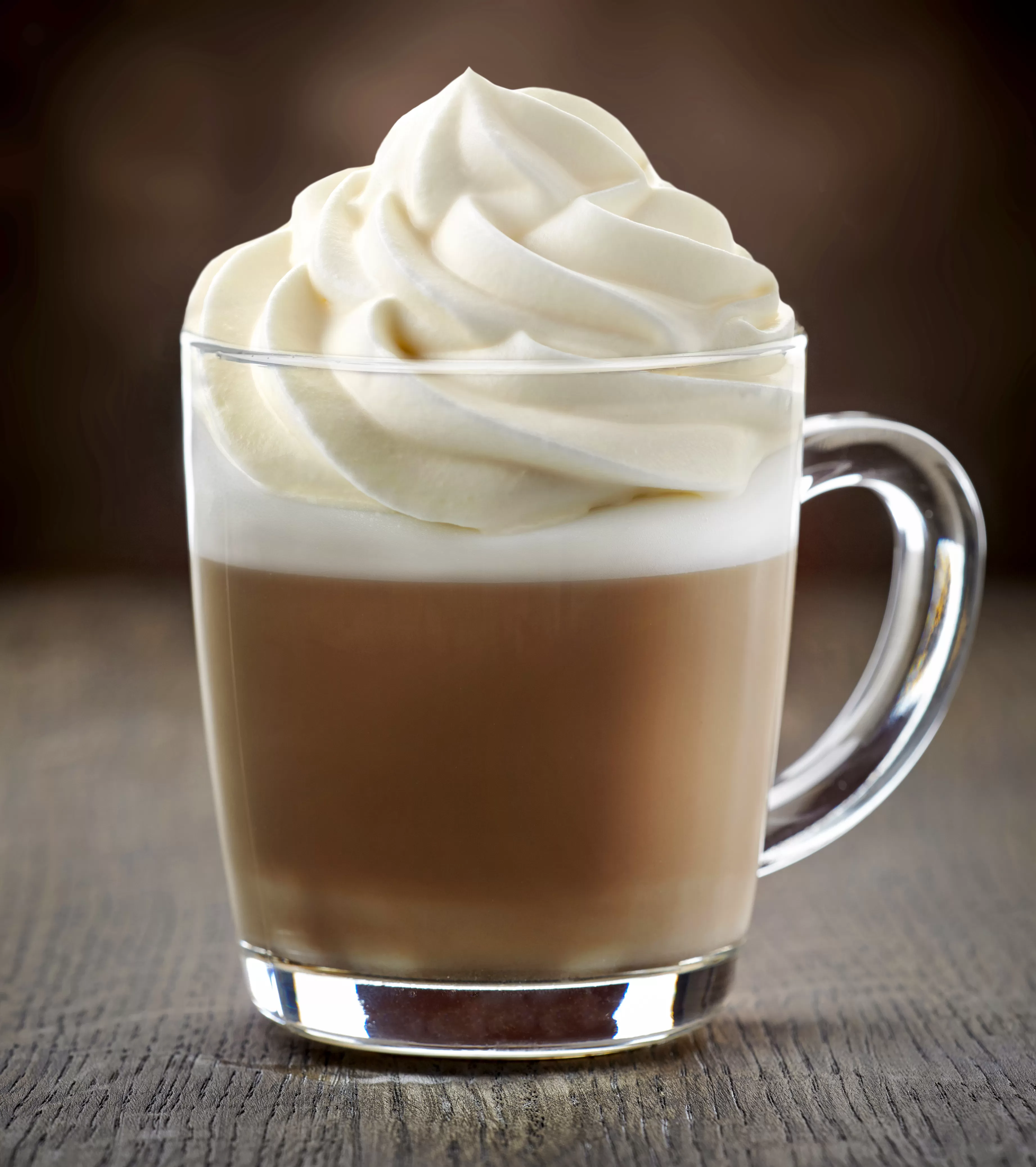 cup of coffee with whip cream on wooden table