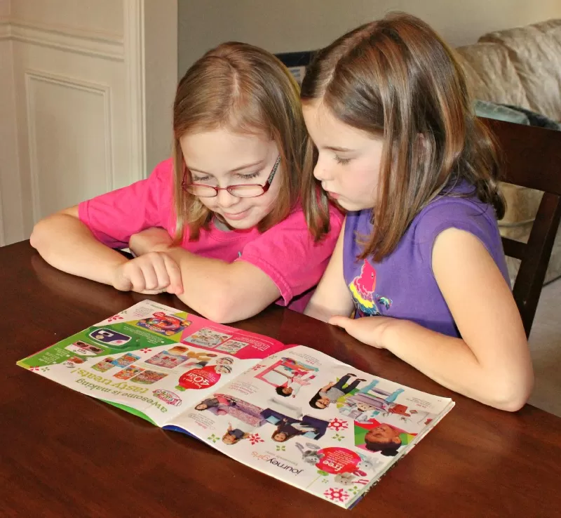 Kids Reading the Great Big Toys R Us Book of Awesome toy catalog