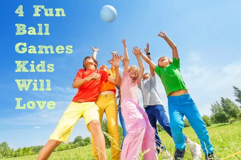 Happy children playing and catching ball in air outside in summer