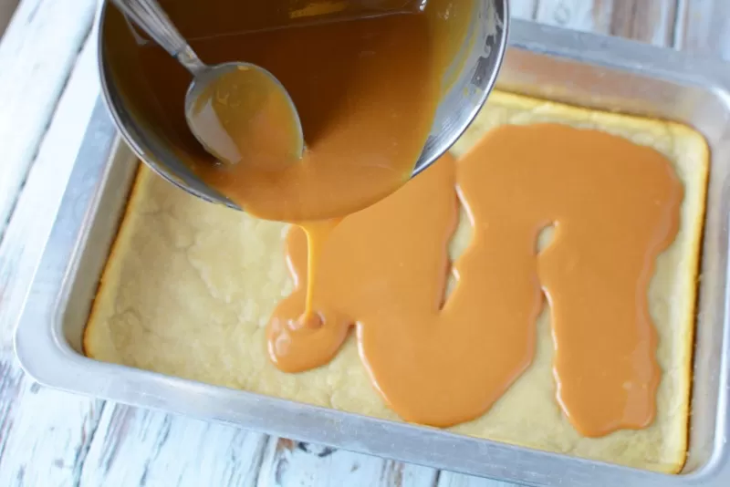 Pouring caramel sauce over cookie dough