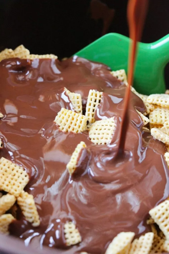 Pouring chocolate mixture of chex mix