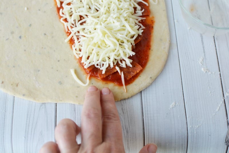 Preparing calzones with dough, sauce, fillings and cheese