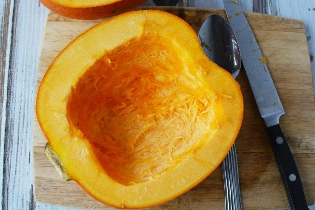 Taking out the seeds from a pumpkin for pumpkin puree