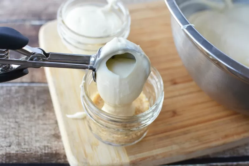 Spooning Cheescake into jar for Cheesecake in a Jar recipe