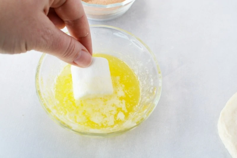 Dipping marshmallow into butter