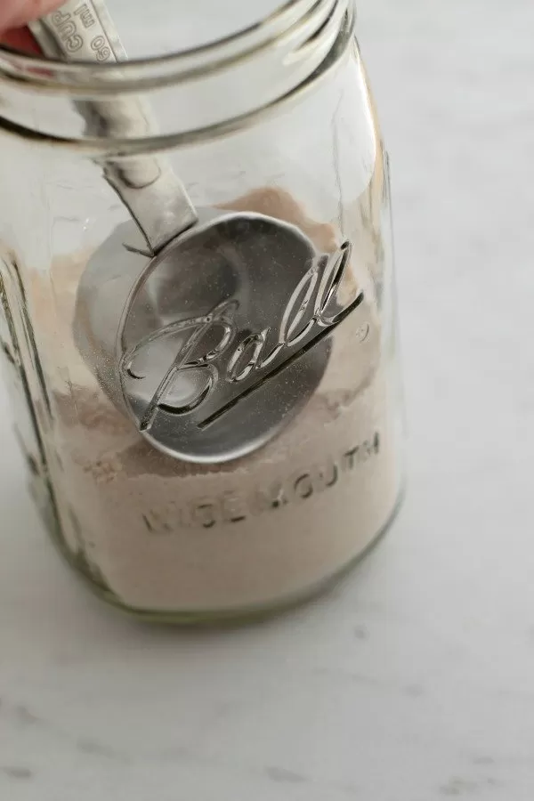 Adding gingerbread cookie ingredients to jar