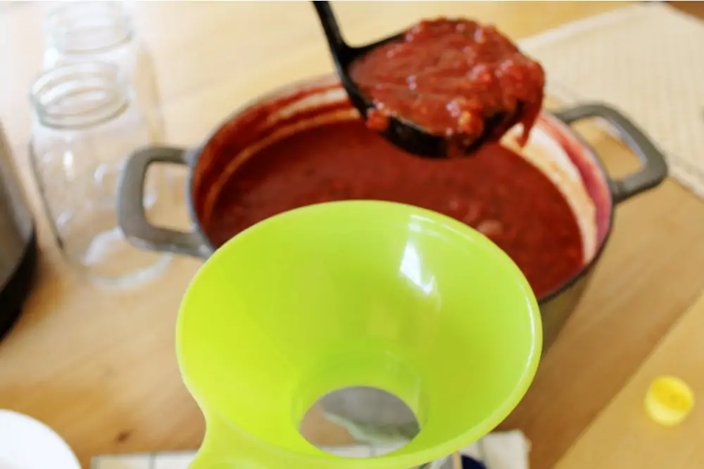 Pouring spaghetti sauce into jars