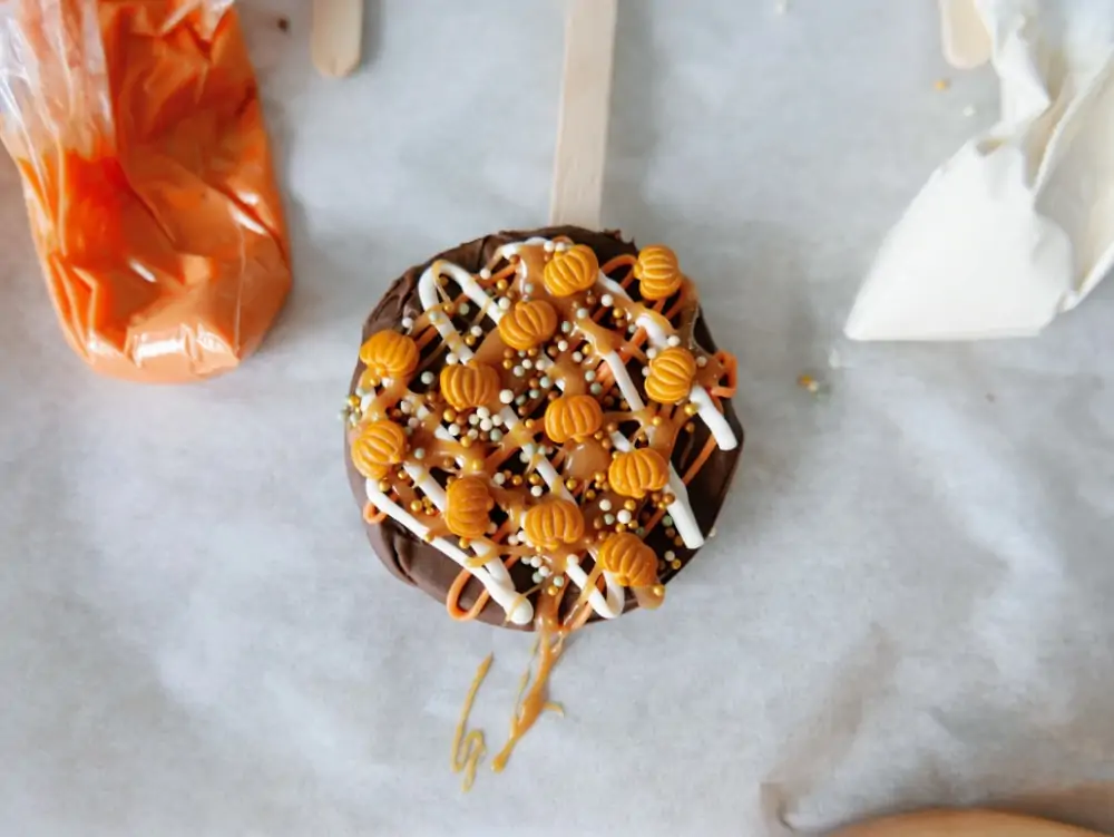 adding sprinkles to caramel apple pops