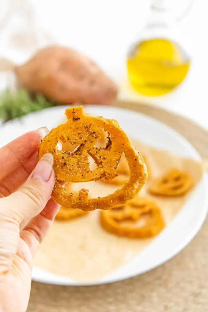 Oven baked sweet potato fries in hand