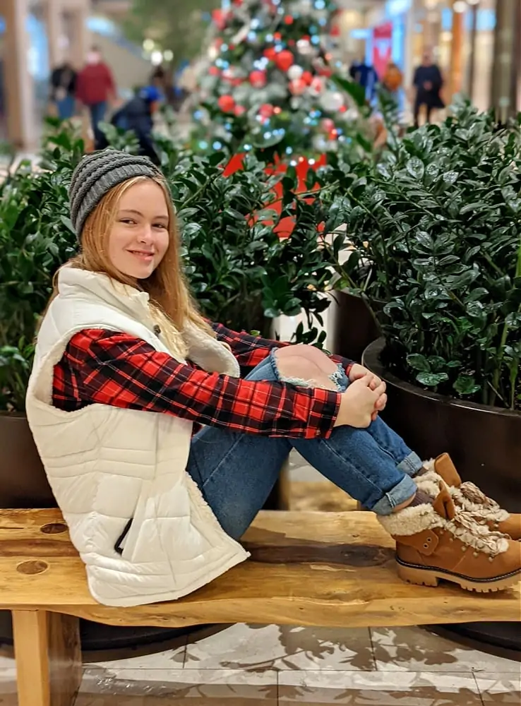 Winter fashion with white vest red flannel jeans & boots with christmas tree