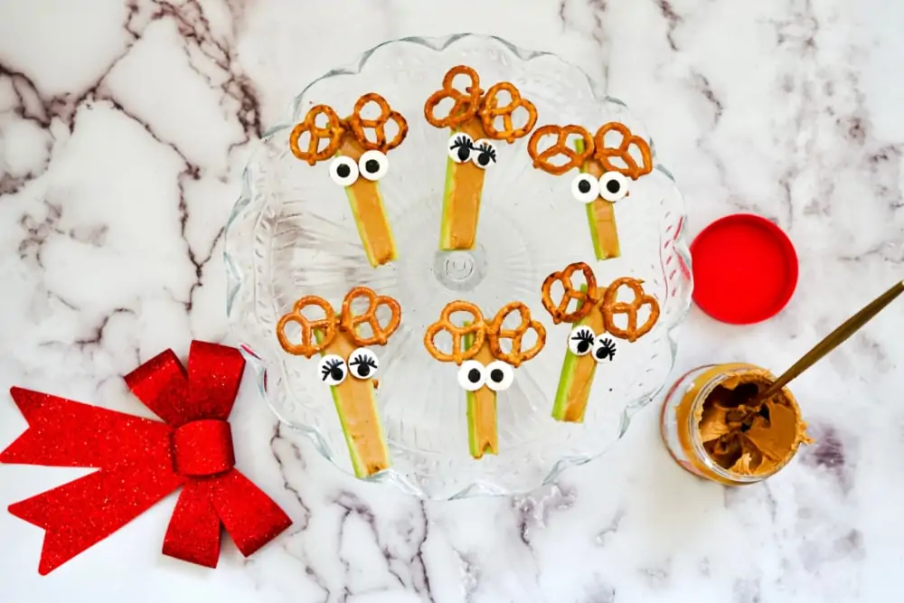 Adding eyes & pretzels with celery for rudolph snacks