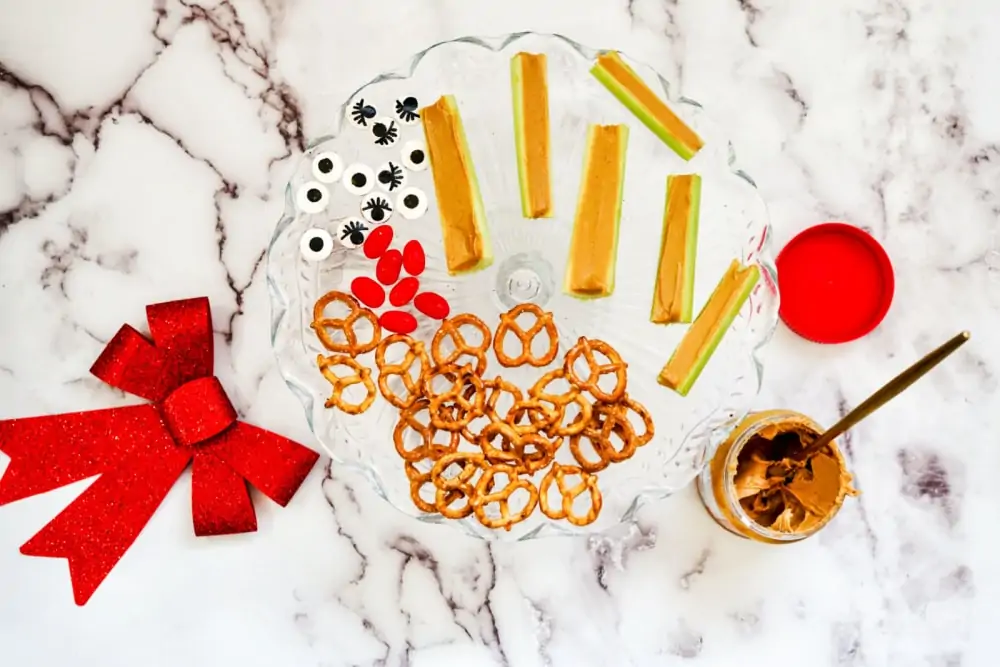 Adding eyes & pretzels with celery for rudolph snacks