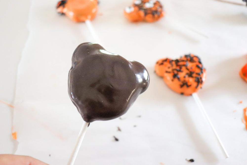 Adding chocolate to oreo halloween pops